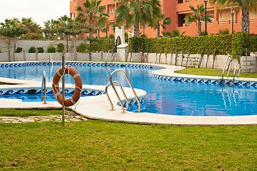 Image showing Blue swimming pool and orange lifebelt