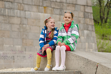 Image showing Two girls sit on a granite ramp
