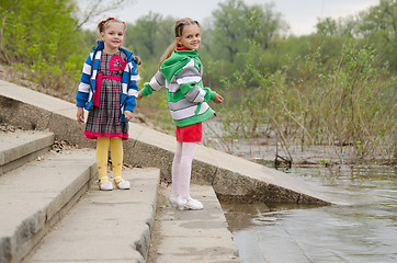 Image showing Two girls standing on the steps near water