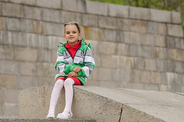 Image showing Girl sitting a granite embankment on ramp