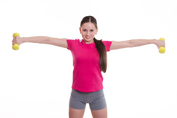 Image showing Sportswoman stretched both arms with dumbbells