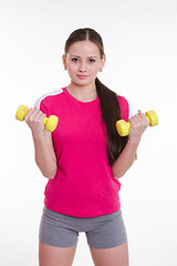 Image showing The athlete pumps weights both hands