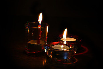 Image showing Three burning candles in the dark