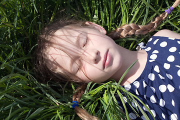 Image showing young girl sleeping on green grass