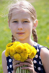 Image showing young girl with a bunch of yellow dandelions 