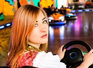 Image showing Beautiful girl in an electric bumper car at amusement park