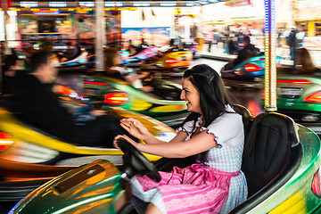 Image showing Beautiful girl in an electric bumper car at amusement park