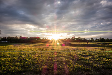 Image showing Sunset over green farm field 