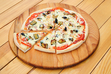 Image showing Sliced pizza with ham, aubergine, black olives and corn