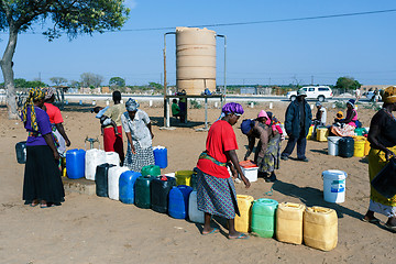 Image showing Unidentified Namibian woman with child near public tank with dri