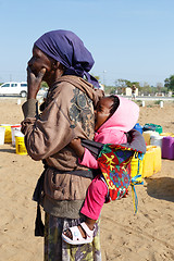 Image showing small namibian child on the back of his mother