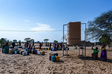 Image showing Unidentified Namibian woman with child near public tank with dri