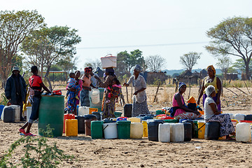 Image showing Unidentified Namibian woman with child near public tank with dri