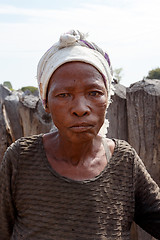 Image showing Portrait of old wrinkled woman behind gate of his village