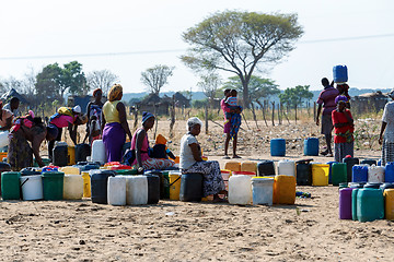 Image showing Unidentified Namibian woman with child near public tank with dri