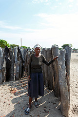 Image showing Portrait of old wrinkled woman behind gate of his village