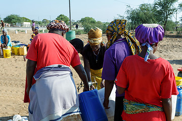 Image showing Unidentified Namibian woman with child near public tank with dri