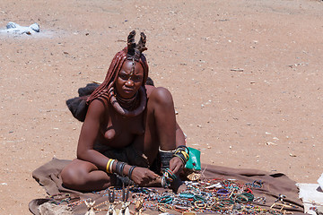 Image showing Himba girl with souvenirs for sale in traditional village
