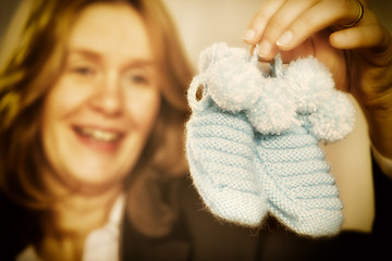 Image showing Blond woman with baby shoes