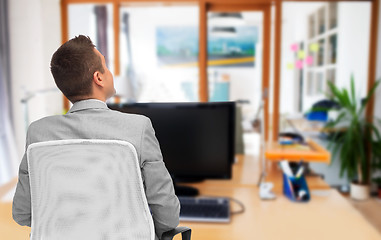 Image showing businessman sitting in office chair from back