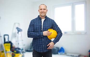 Image showing smiling man holding helmet over room background