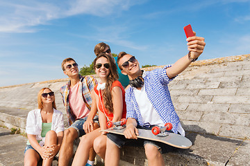 Image showing group of smiling friends with smartphone outdoors