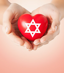 Image showing close up of hands holding heart with jewish star