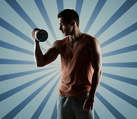 Image showing young man with dumbbell flexing biceps