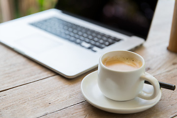 Image showing close up of laptop and coffee cup on office table