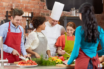 Image showing happy friends and chef cook cooking in kitchen