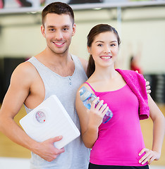 Image showing two smiling people with scale in the gym