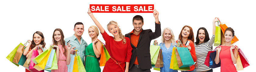 Image showing happy people with red sale sign and shopping bags