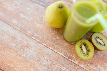 Image showing close up of fresh green juice and fruits on table