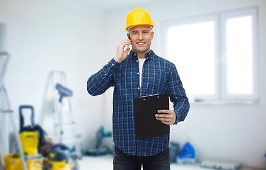 Image showing smiling builder in helmet calling on smartphone