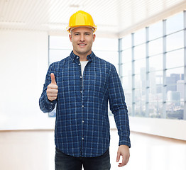 Image showing smiling male builder in helmet showing thumbs up