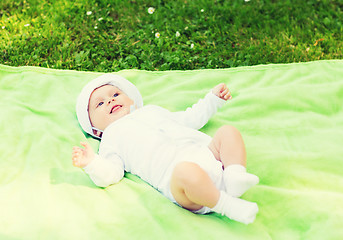 Image showing smiling baby lying on floor and looking up