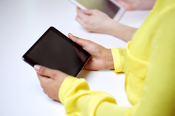 Image showing close up of female hands with tablet pc at table