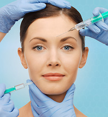 Image showing woman face and surgeon hands with syringes