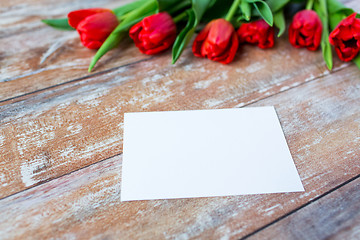 Image showing close up of red tulips and blank paper or letter