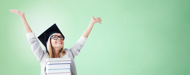 Image showing happy student in mortar board cap with books