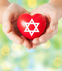 Image showing close up of hands holding heart with jewish star