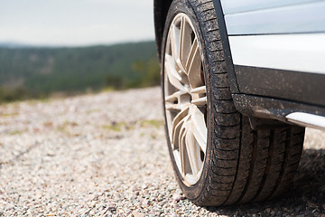 Image showing close up of dirty car wheel on cliff