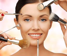 Image showing happy woman applying professional make-up