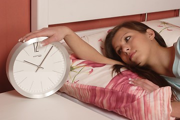 Image showing Young woman with clock