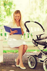 Image showing happy mother with book and stroller in park