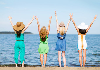 Image showing girls looking at the sea with hands up