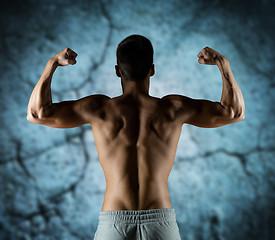 Image showing young man or bodybuilder showing biceps