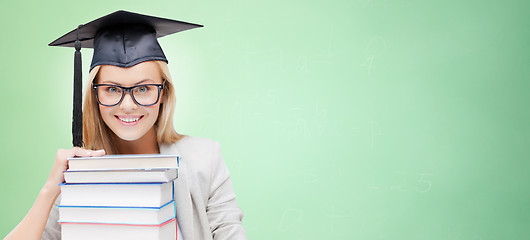 Image showing happy student in mortar board cap with books