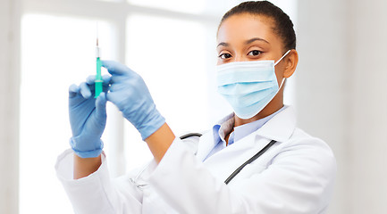 Image showing african doctor holding syringe with injection