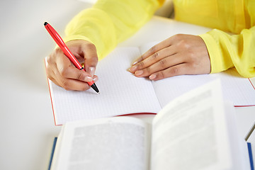 Image showing close up of female hands writing to notebook